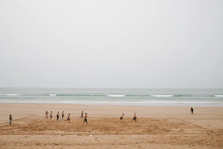 Wide ocean view in Agadir Morocco with surfers in the distance during a calm surf session