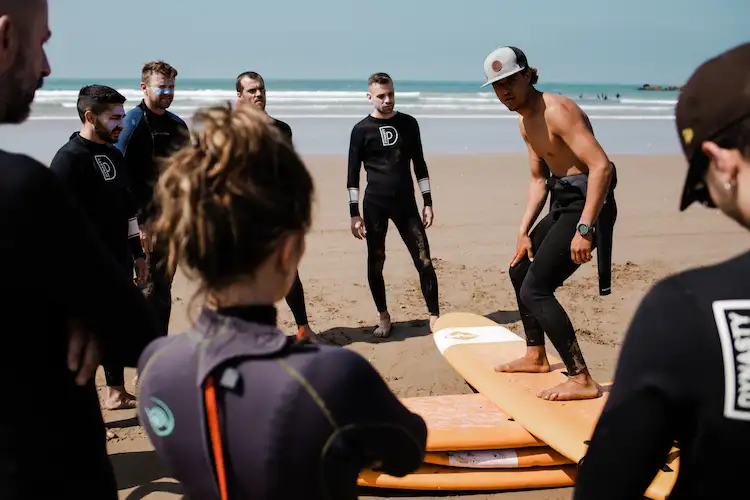 Surf students practicing together in the water with instructors at Green Waves Morocco
