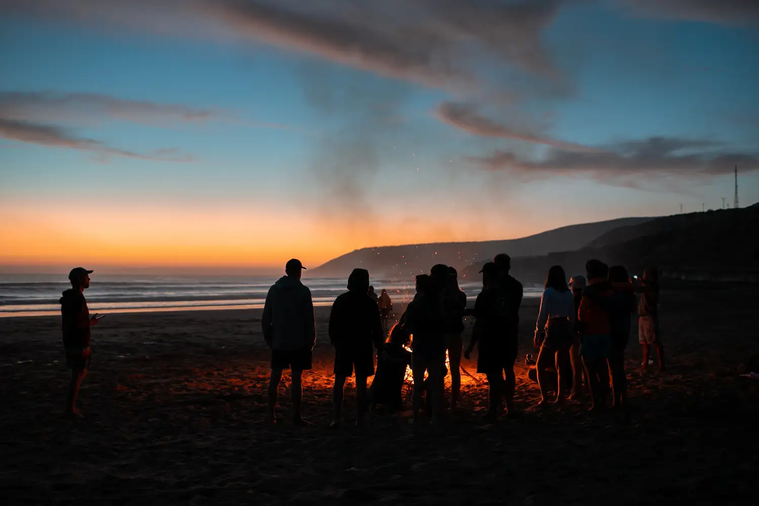 Surfers sitting together watching the ocean in Tamraght Morocco during golden hour