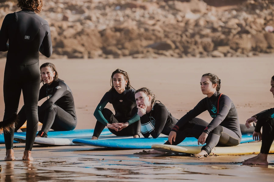 Green waves Morocco Surf coach explaining wave technique to beginner surfers in Tamraght Morocco